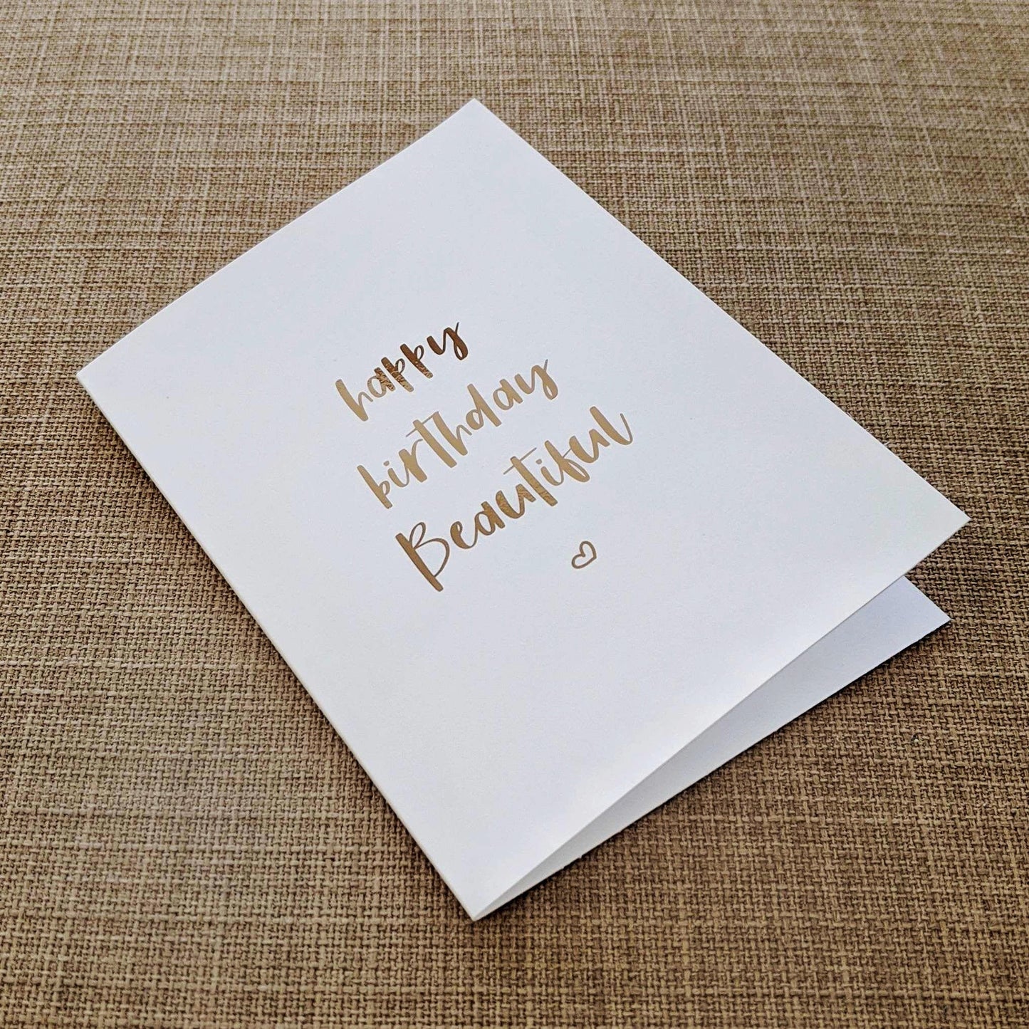 Greeting card with foiled lettering of "happy birthday Beautiful"